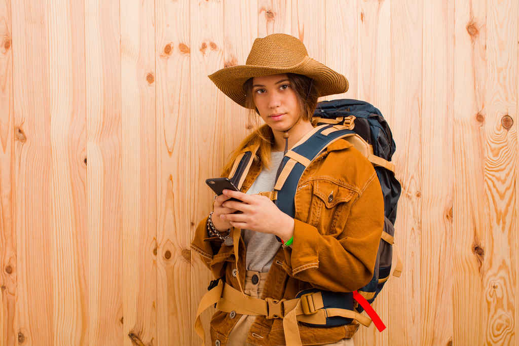 young pretty latin trekker woman against wooden wall