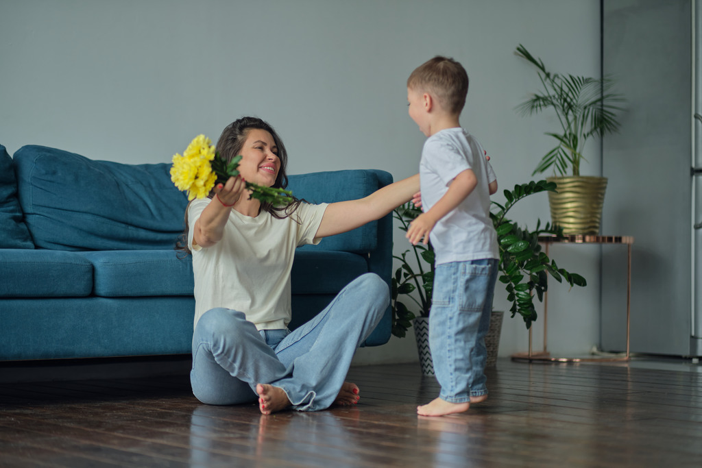 Happy mother day. child son congratulates mother on holiday and gives flowers.